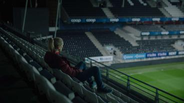  Helena, played by Ane Dahl Torp, sits in an empty stadium staring out at the field. | "Home Ground"
