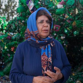 Hayedeh Shirzadi stands in front of a mountain of recyclable plastic. | "Mother of the Earth"